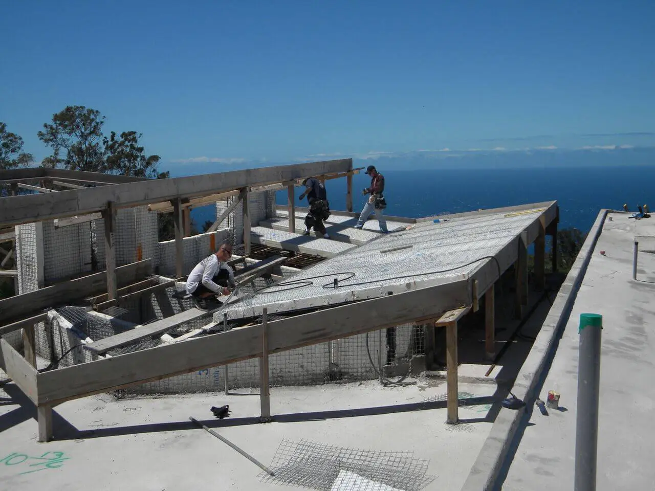 A group of men working on the roof of a building.