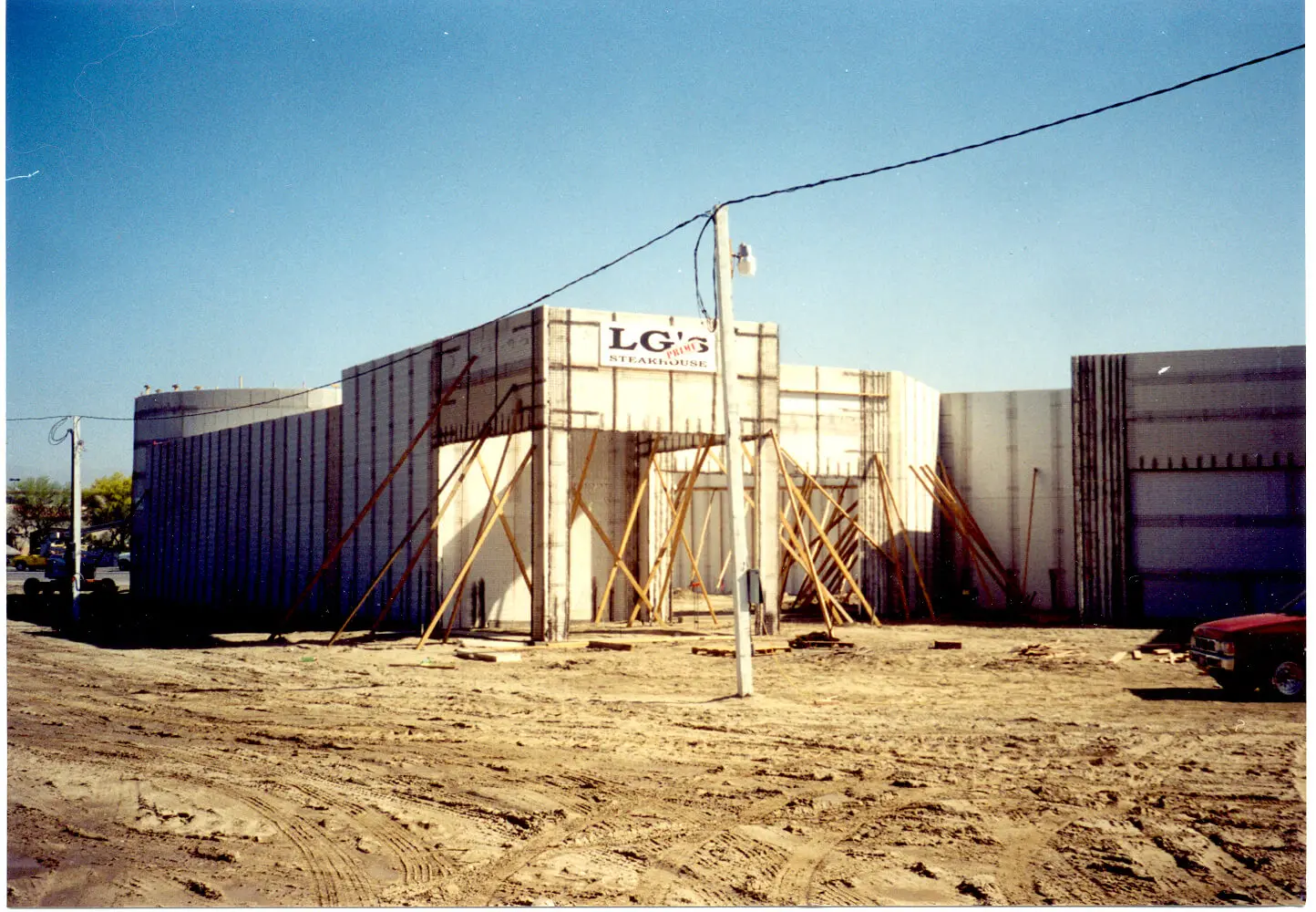 A building under construction with a car in front of it.