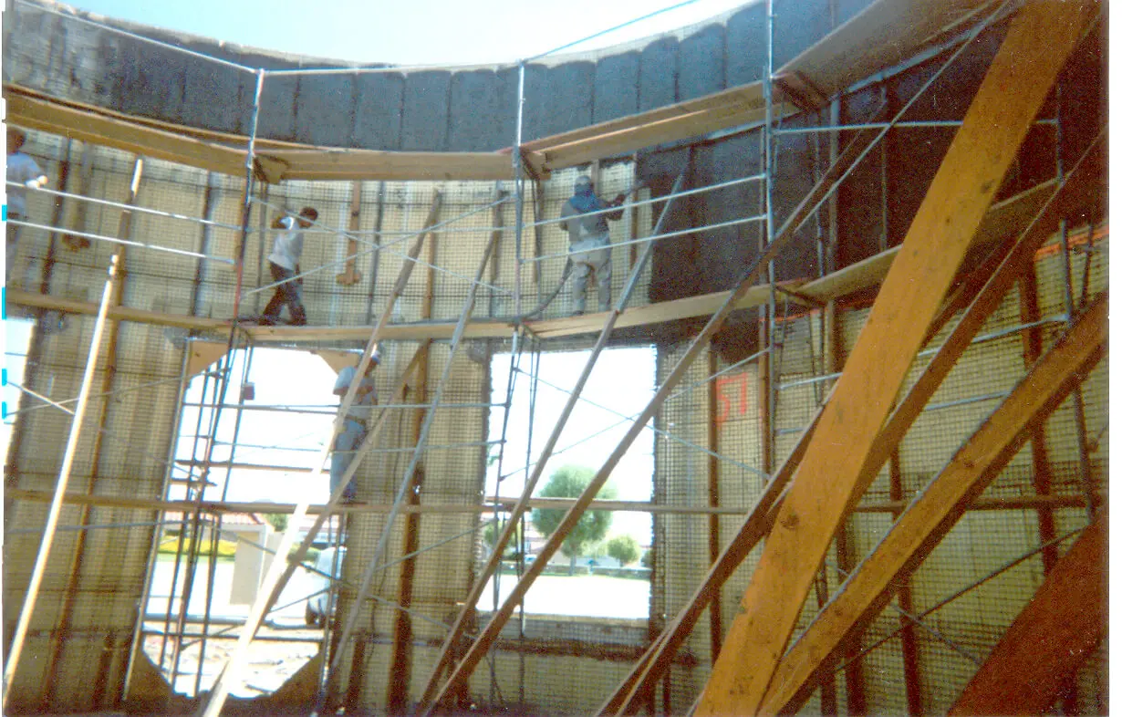 A group of people working on scaffolding in a building.