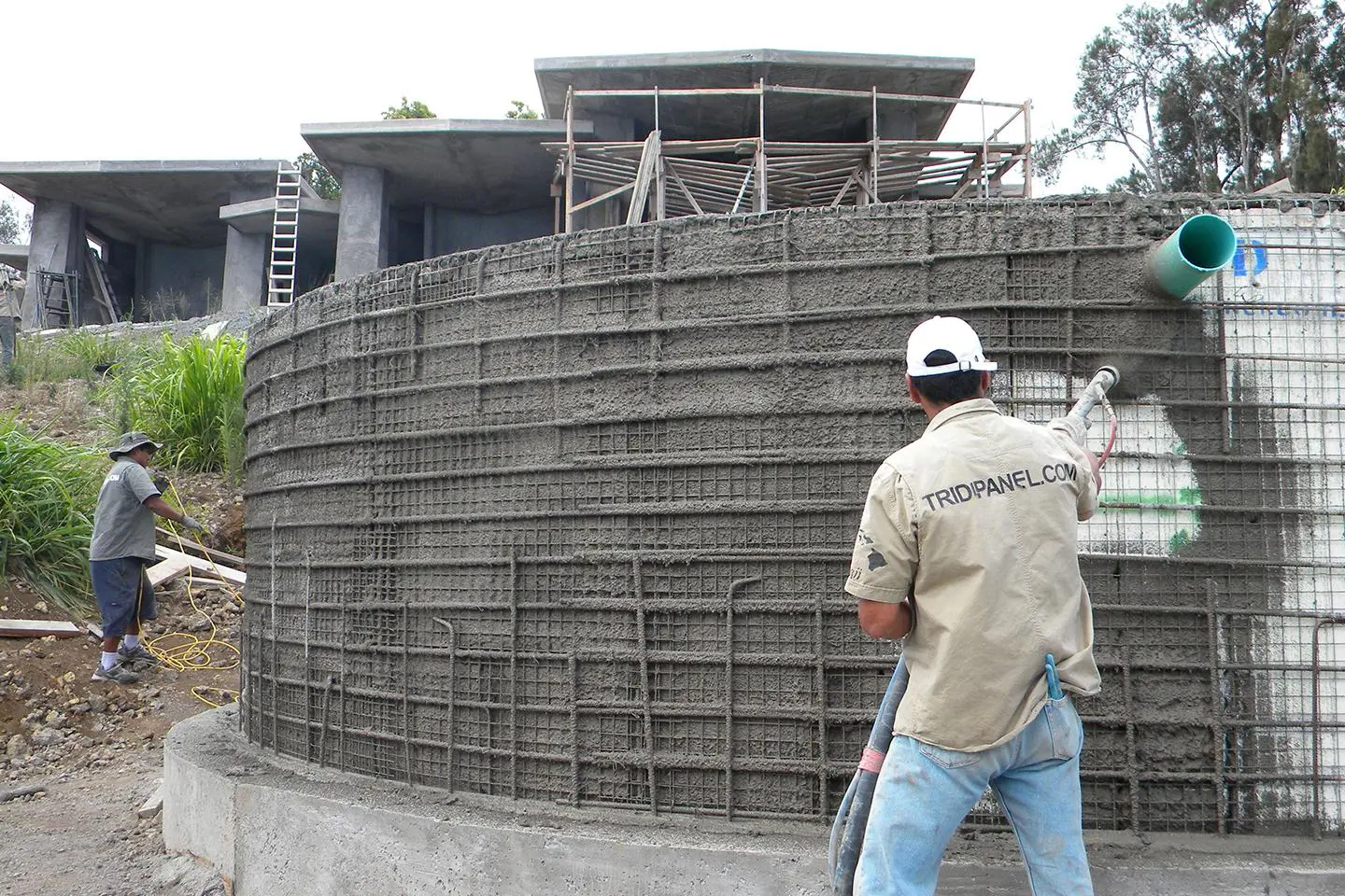 Worker spraying concrete on a wall.