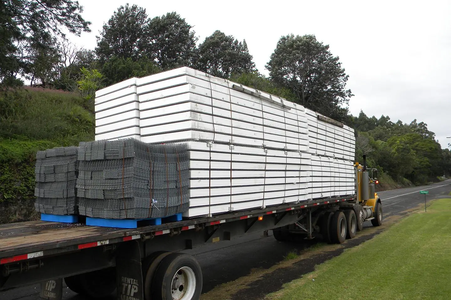 A truck with stacks of lumber on it's flatbed.