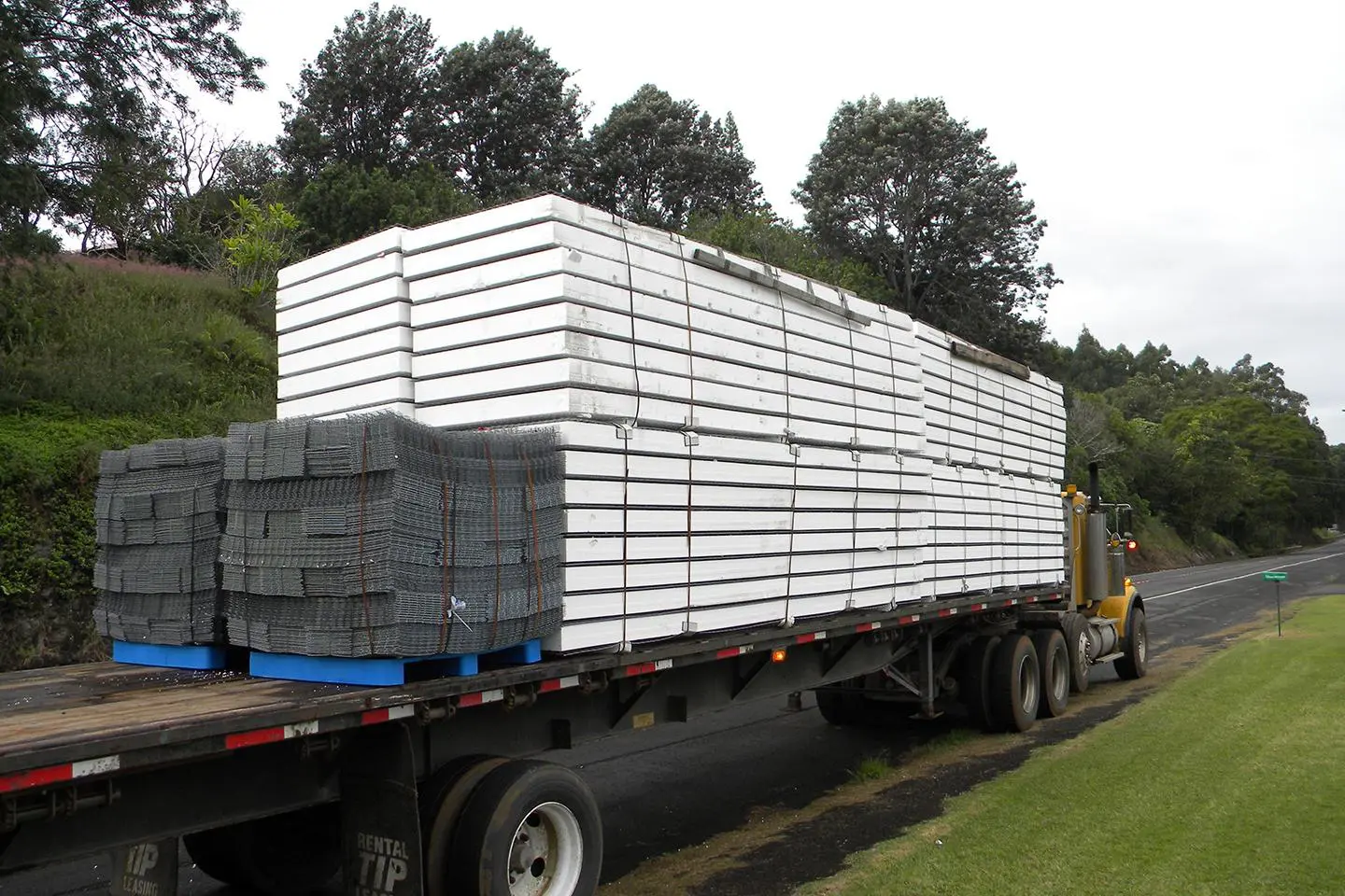 A truck with many stacks of lumber on it.