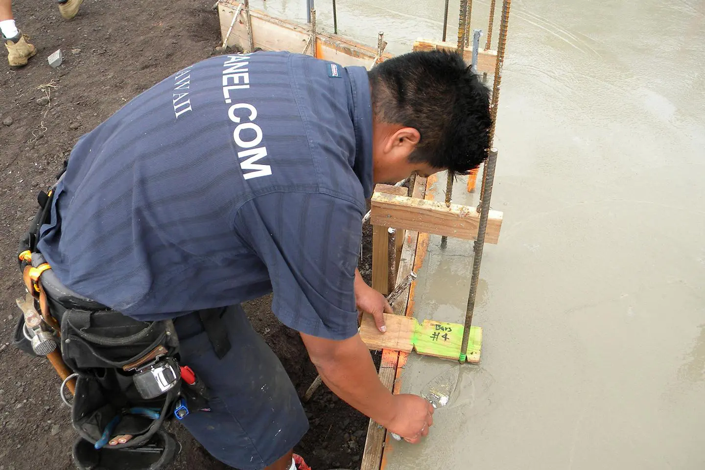 Construction worker smoothing wet concrete.