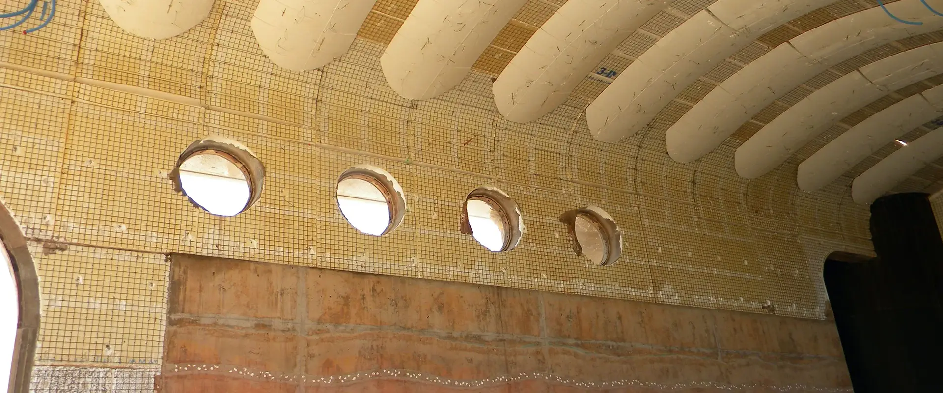 A close-up of a tiled ceiling with circular openings.
