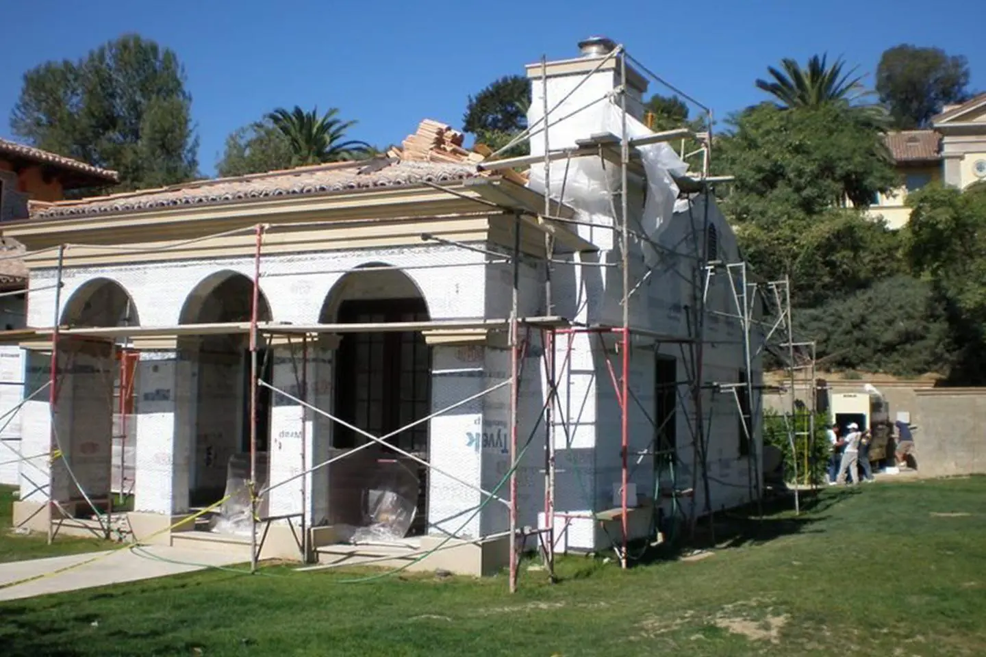 A white house under construction with scaffolding.