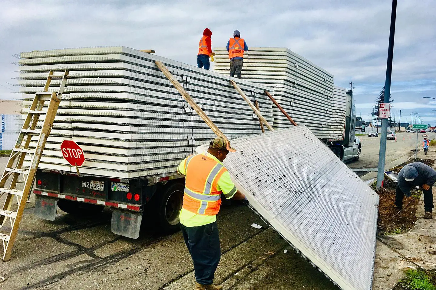 A man in an orange vest is loading materials.