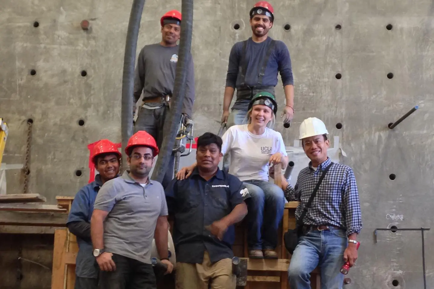 A group of people wearing hard hats and posing for the camera.