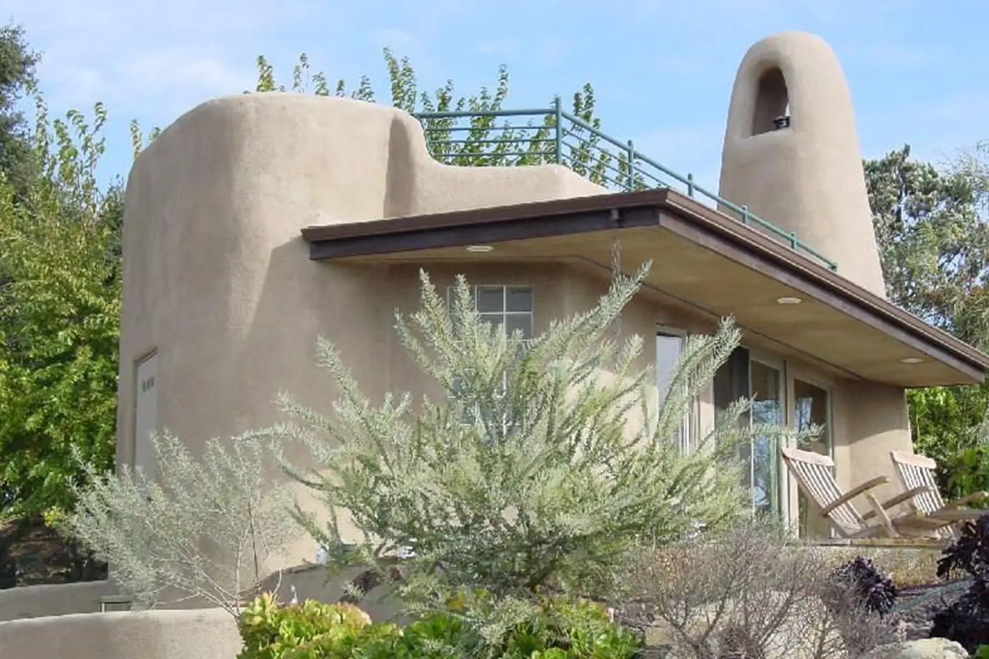 A house with a balcony and a roof over the top of it.