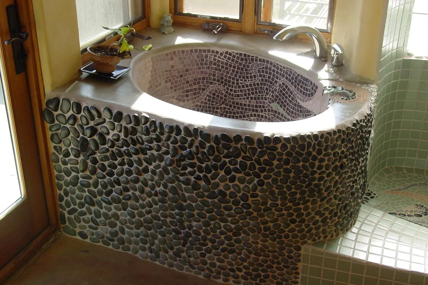 A bathroom with a sink and a tub made of rocks.