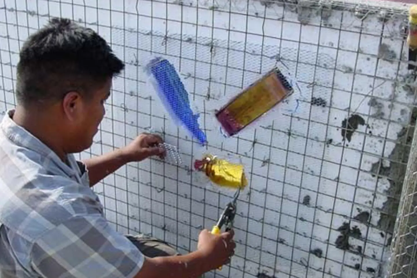 A man is using an electronic device to check the wall.