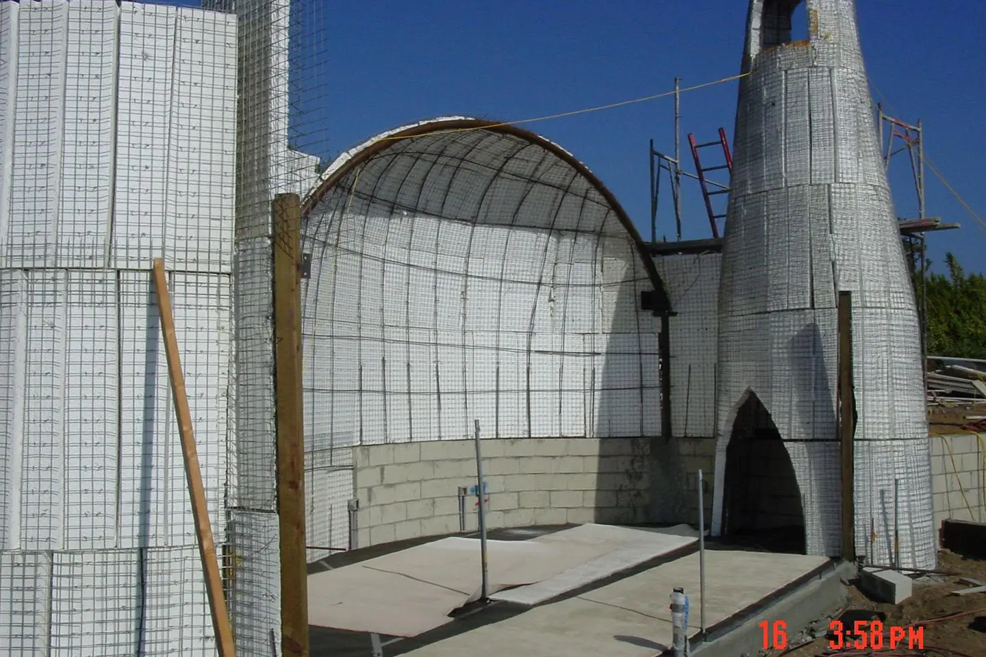 Construction of a curved building with scaffolding.