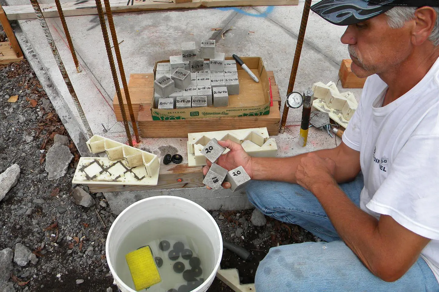 A man sitting on the ground next to some boxes of soap.