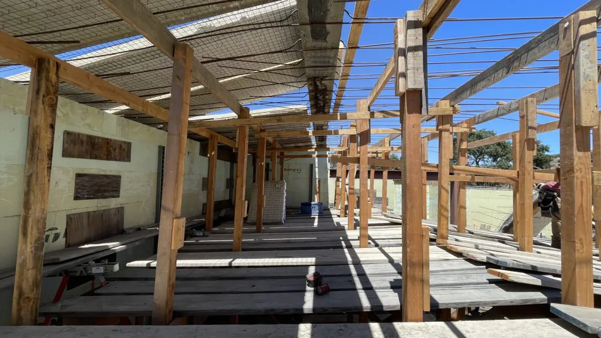 Wooden frame construction under a blue sky.