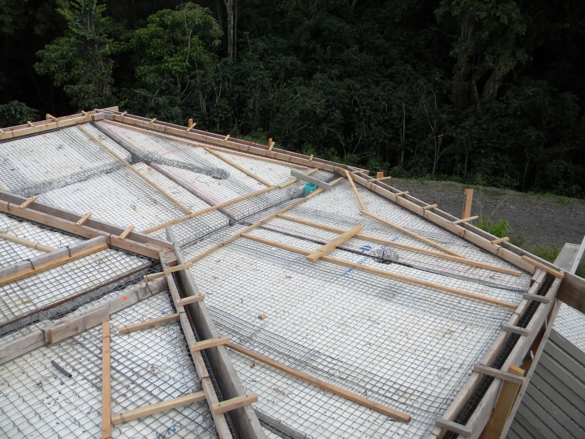 Concrete foundation with wire mesh and wood supports.