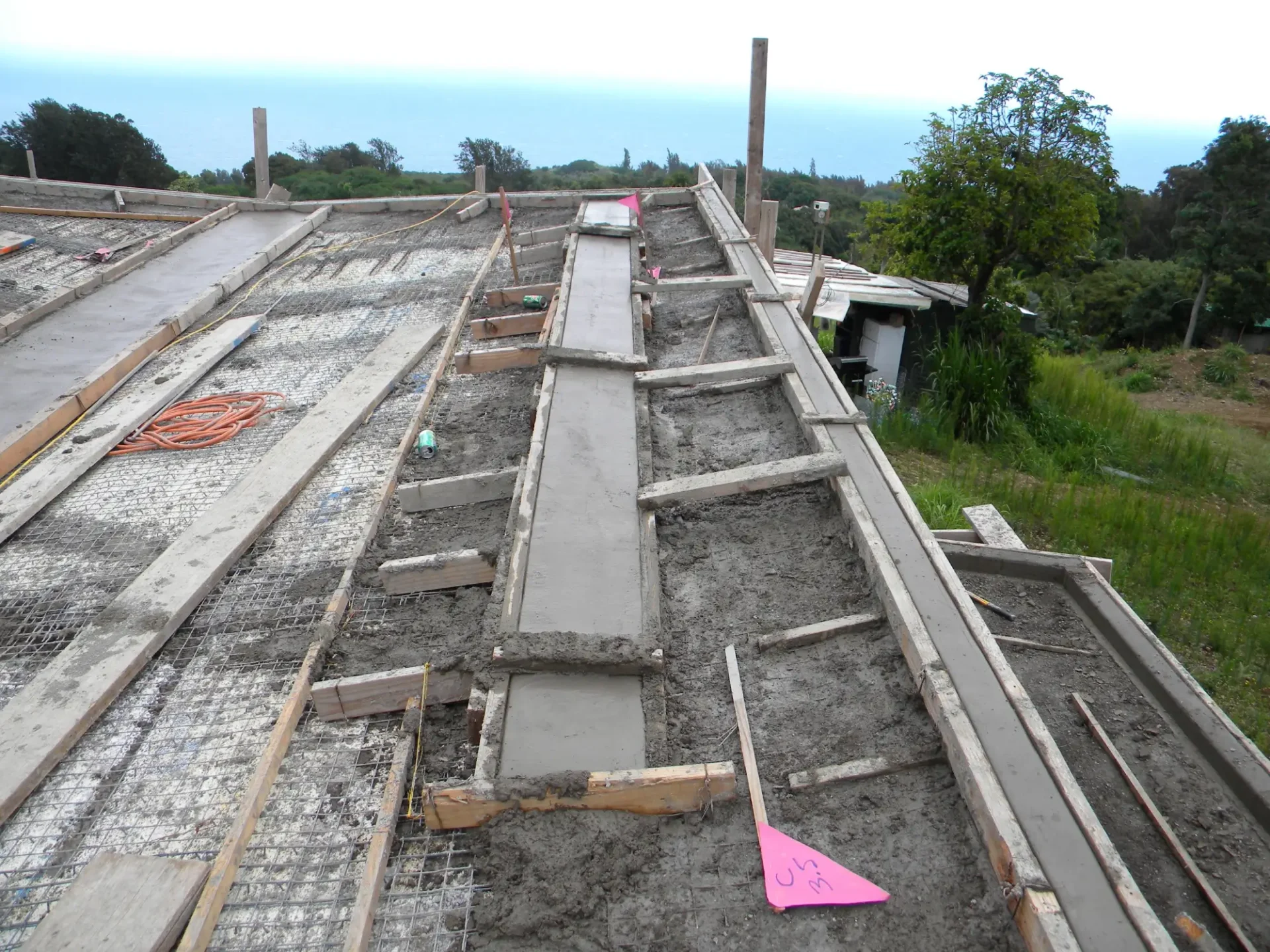 Concrete being poured on a roof frame.