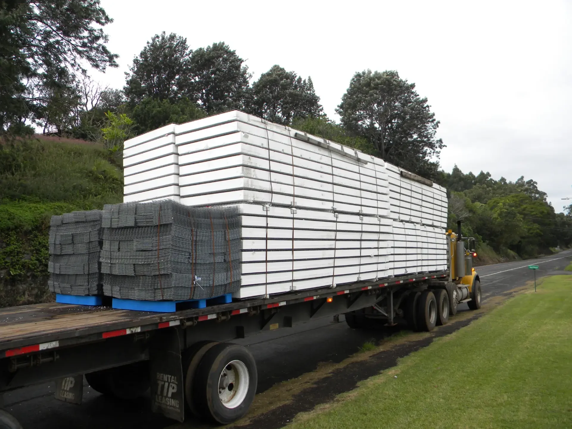 Semi-trailer truck loaded with white panels.