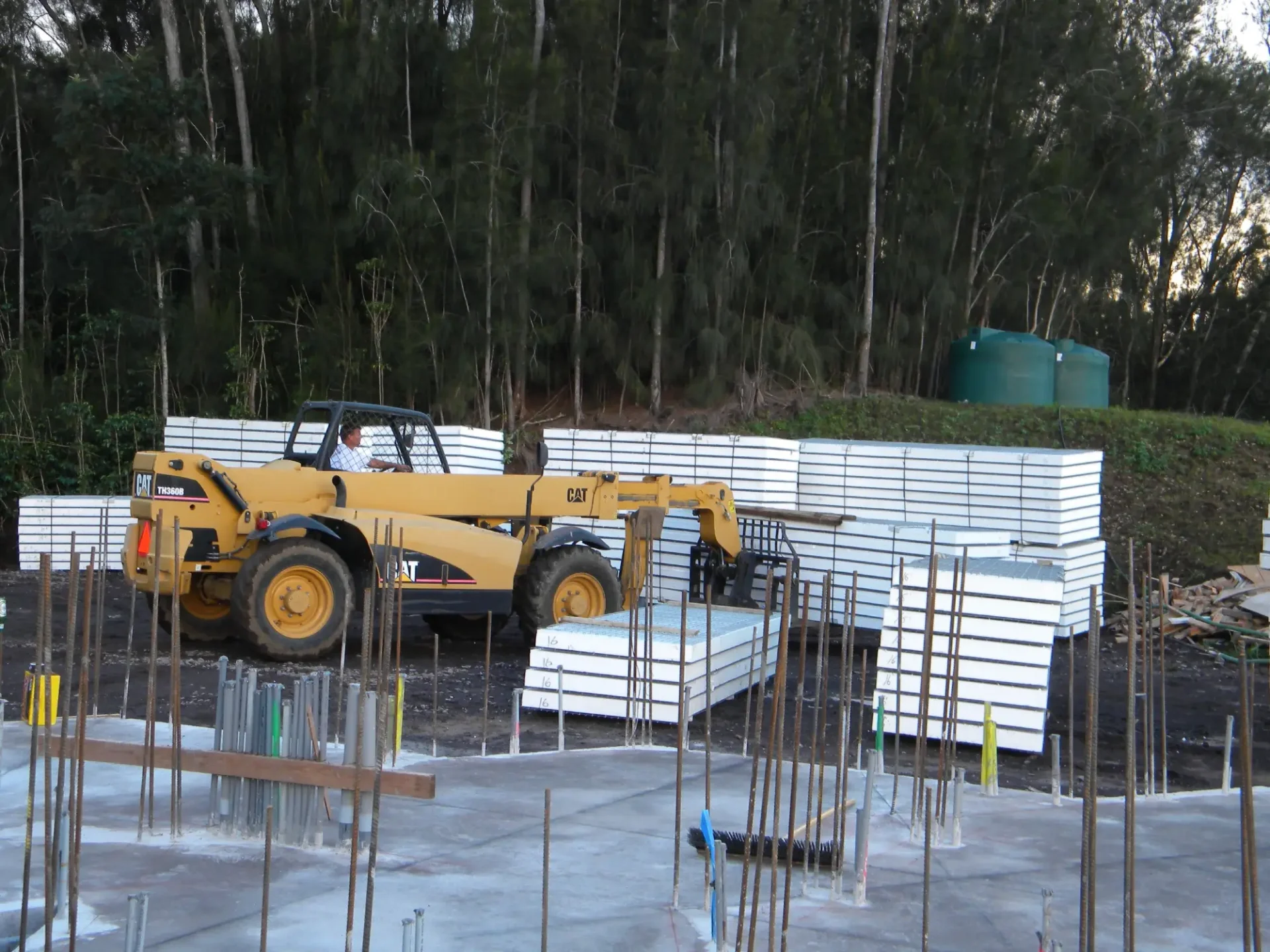 Yellow forklift moving building materials.