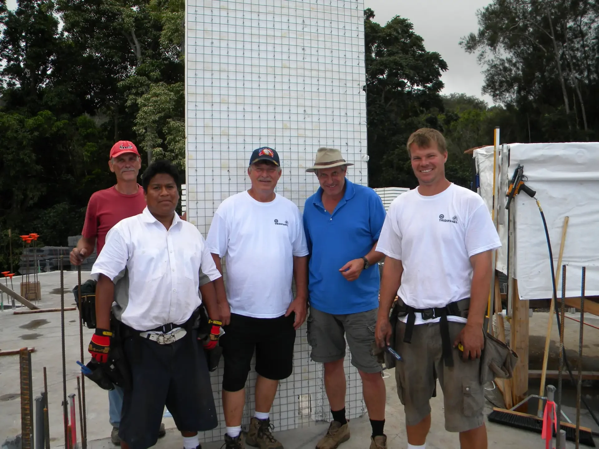 Four men standing in front of a wall.