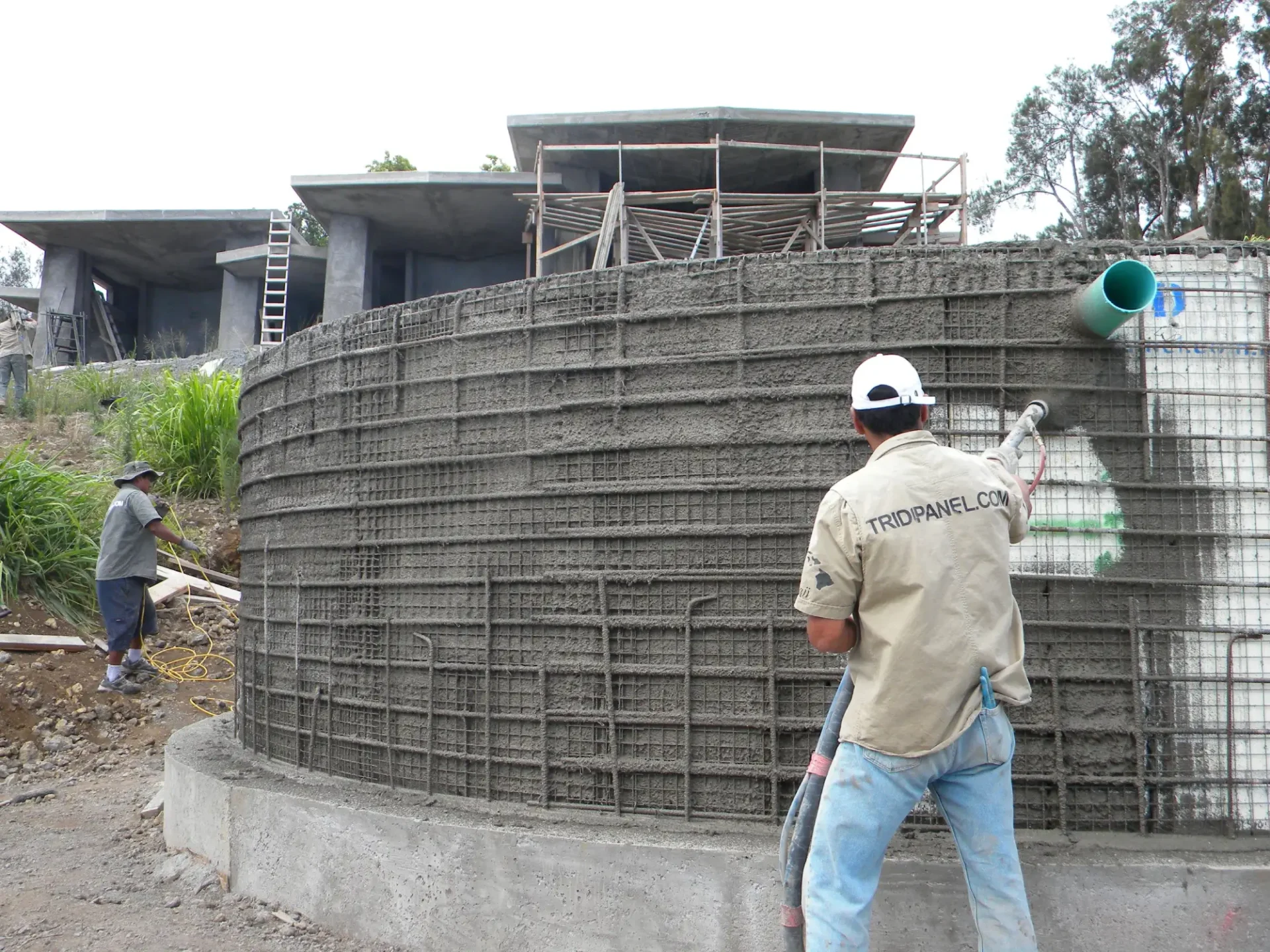 Construction worker spraying concrete onto a wall.